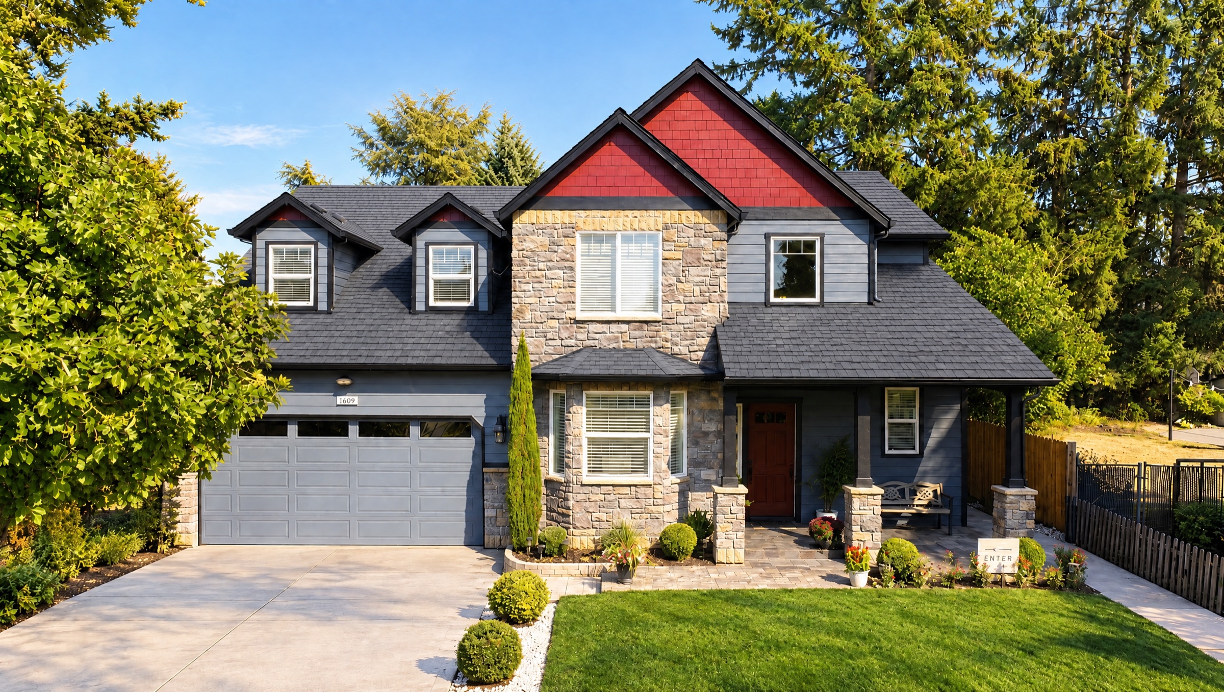 The front of Rose Manor: a two-story home with red gables, a stone facade and a green front lawn under tall firs.